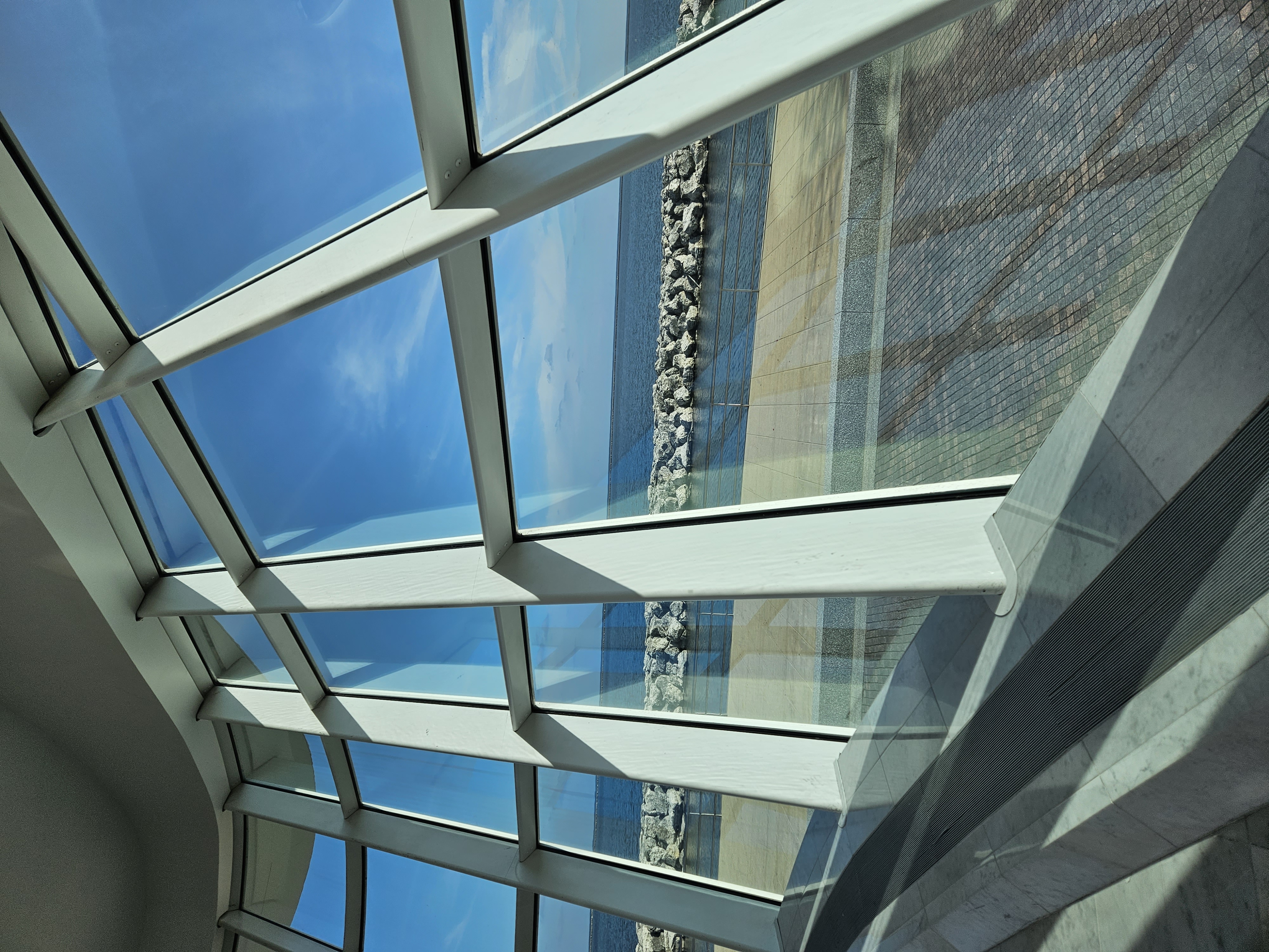 inside glass building with lake in background