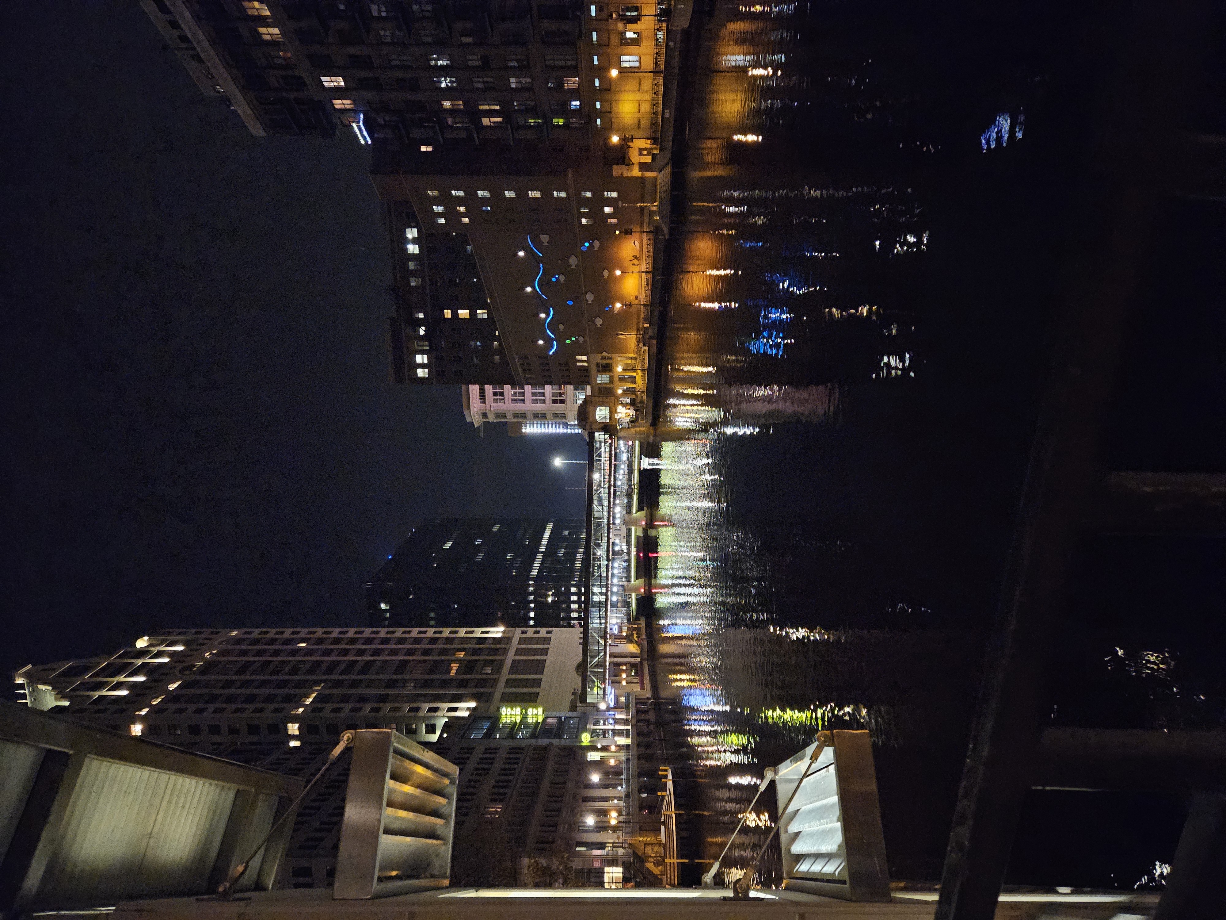 nighttime river reflection on city