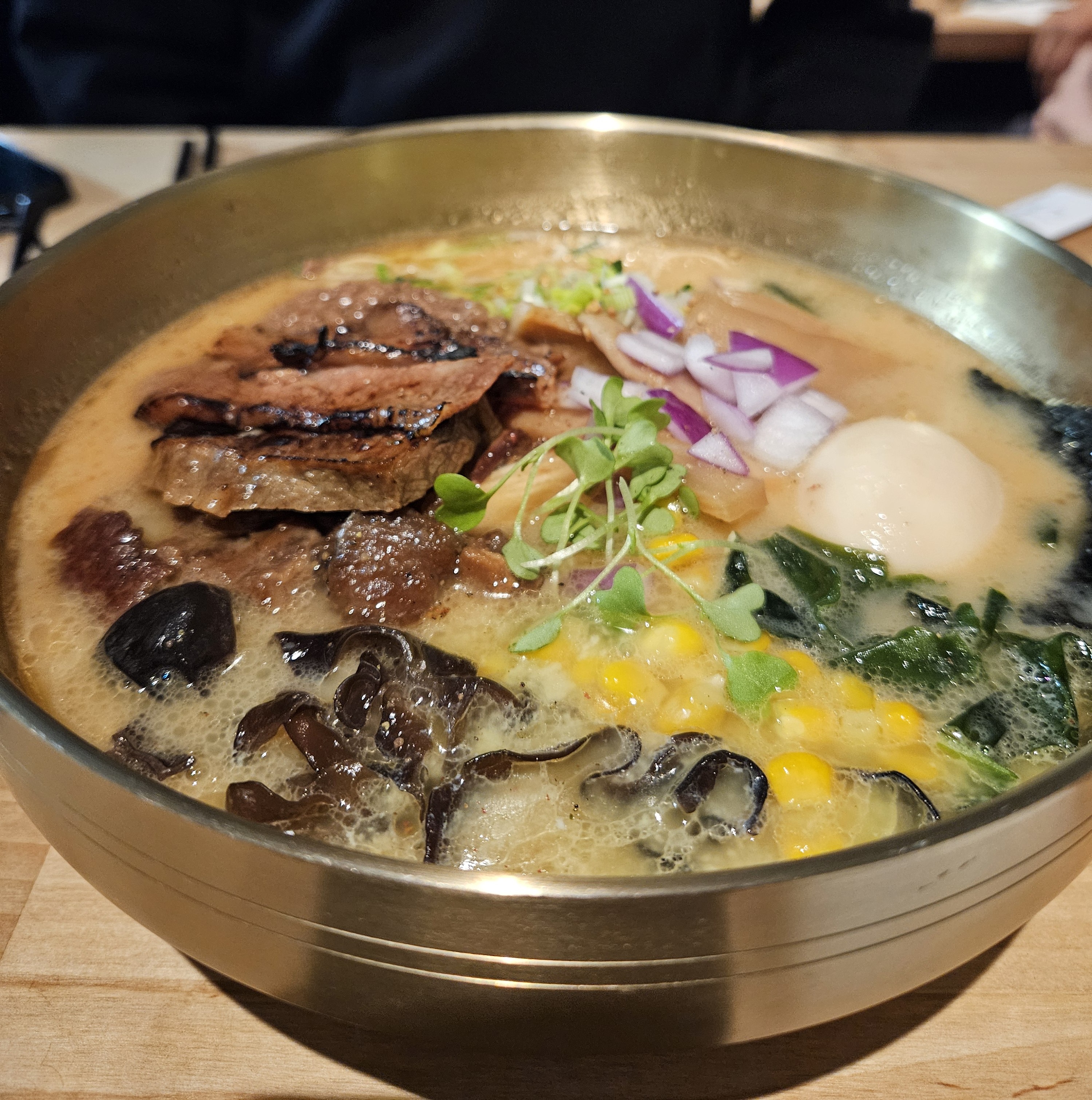 thick ramen broth in silver bowl