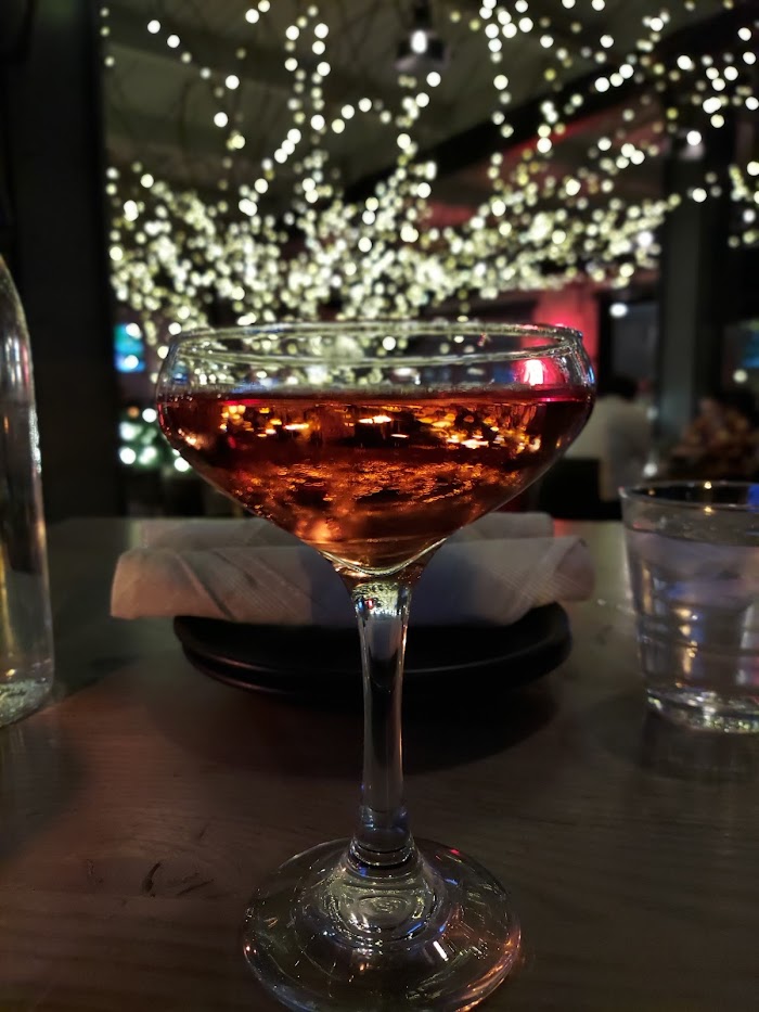 glass of rose in front of a golden light tree