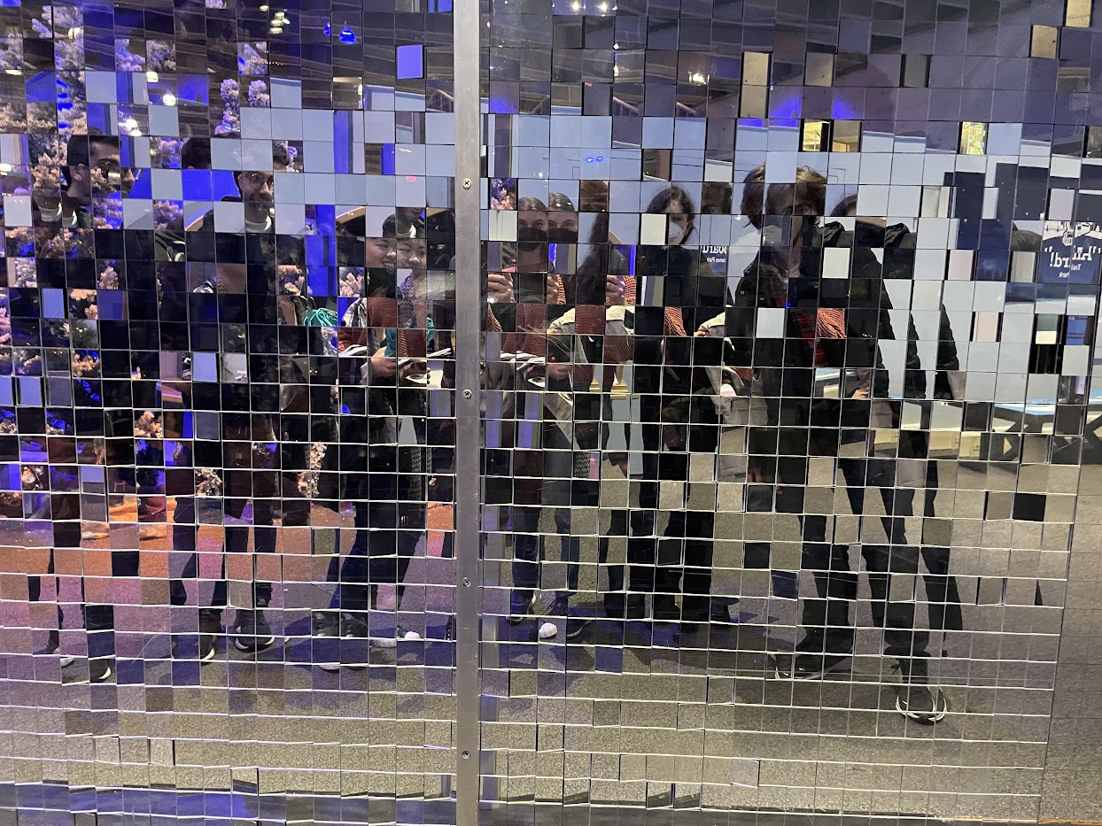 my friends standing in front of checkerboard of mirror squares