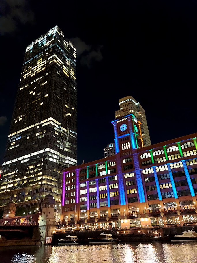 purple and blue lights shining on building on a river