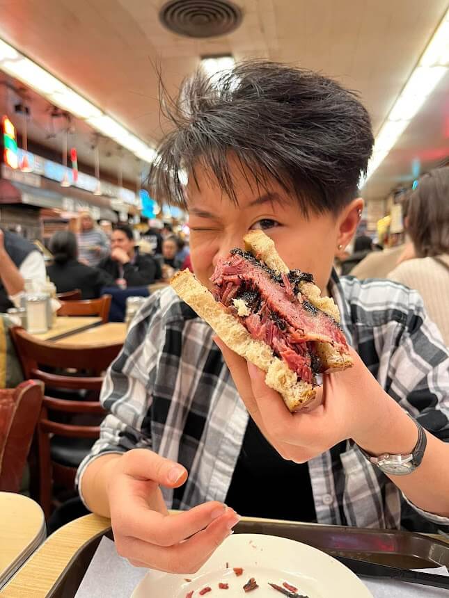 kaylee holding up a pastrami sandwich