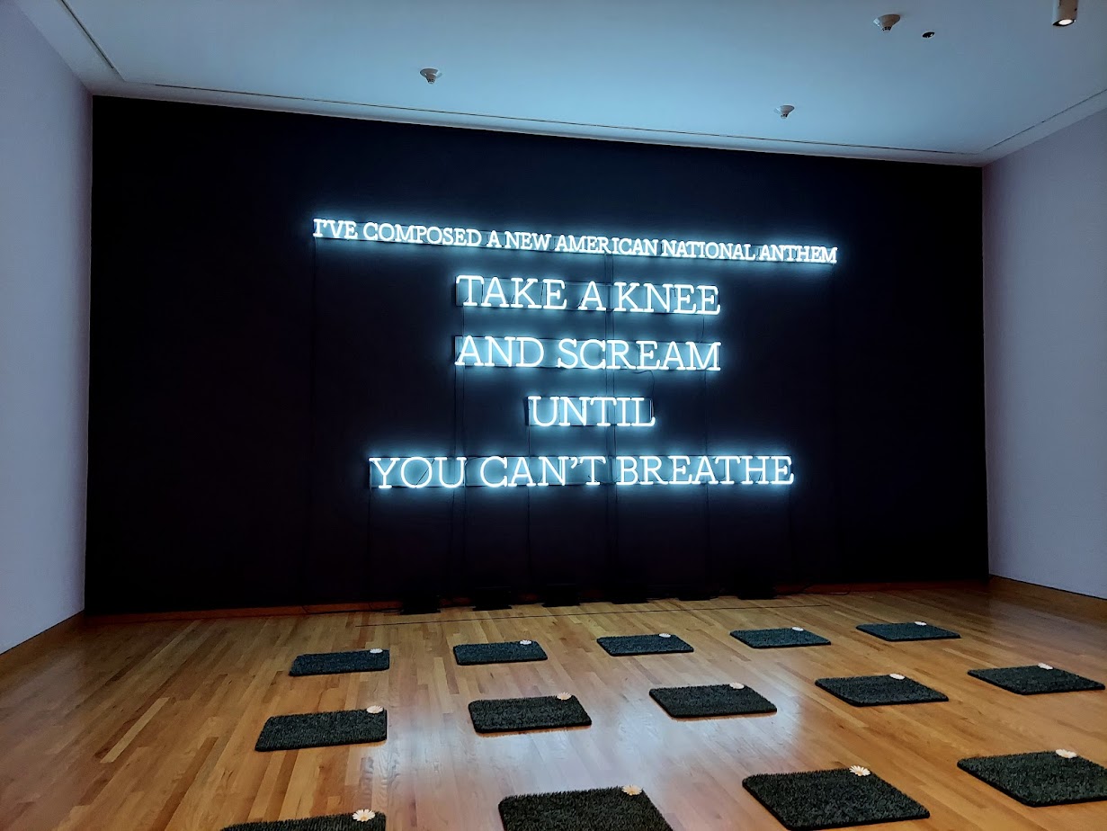 mats on the floor and a large neon sign saying 