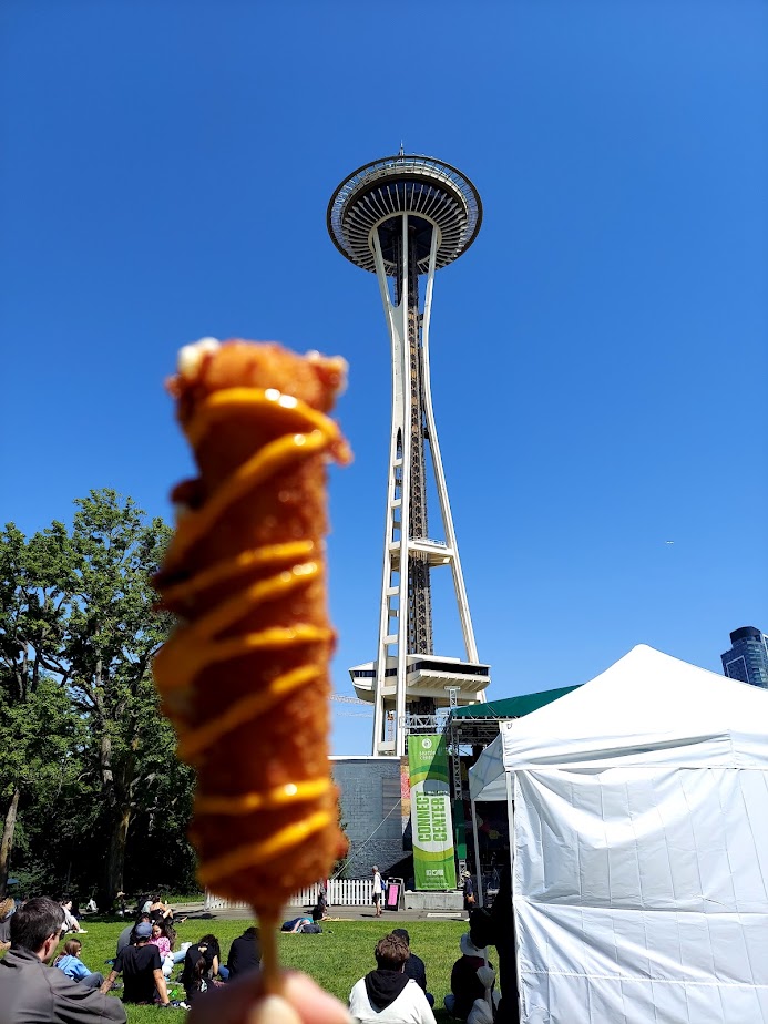 korean corn dog held up to the space needle